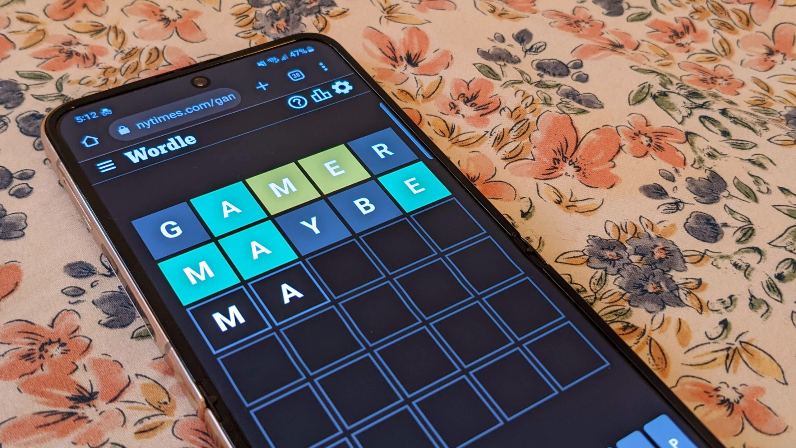 Person playing Wordle on a phone with a flowery background