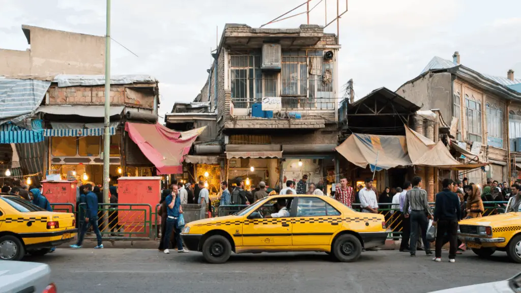 Sanandaj, Iran - October 9, 2014: People walk around street market with line of taxi cars of yellow color on October 9, 2014. capital of Kurdish culture & Kurdistan Province, Sanandaj has population of 380,000