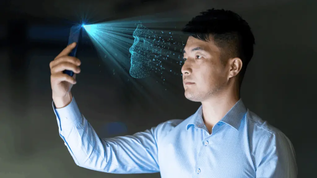 Young man using facial recognition technology with mobile phone - stock photo