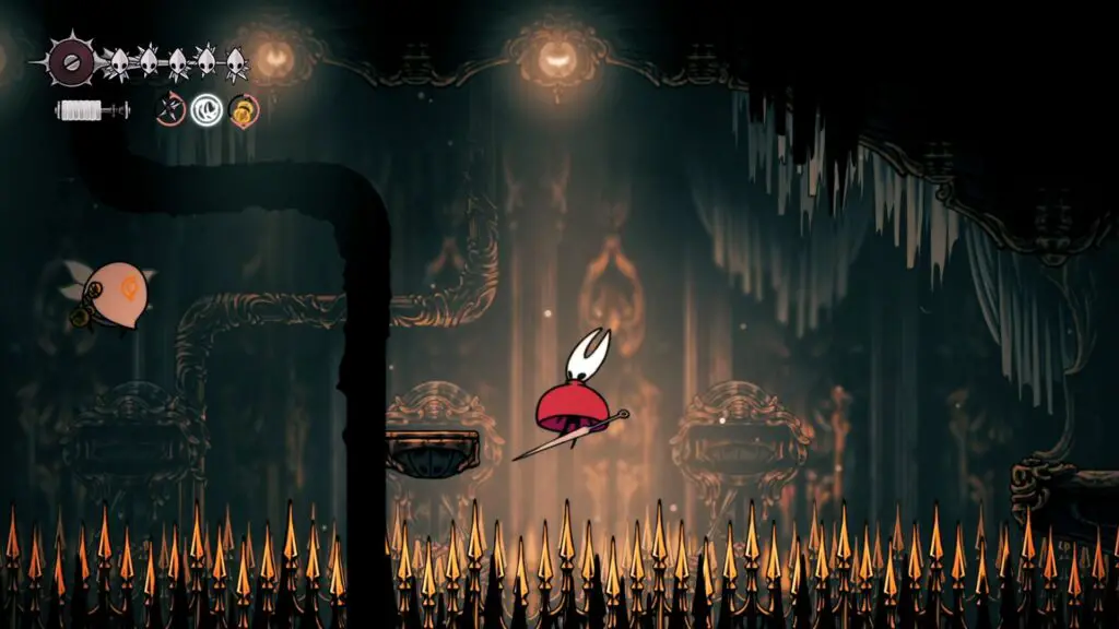 A screenshot of Hollow Knight: Silksong. A small character with a white face and a red cape billowed out like an umbrella hovers over spikes.