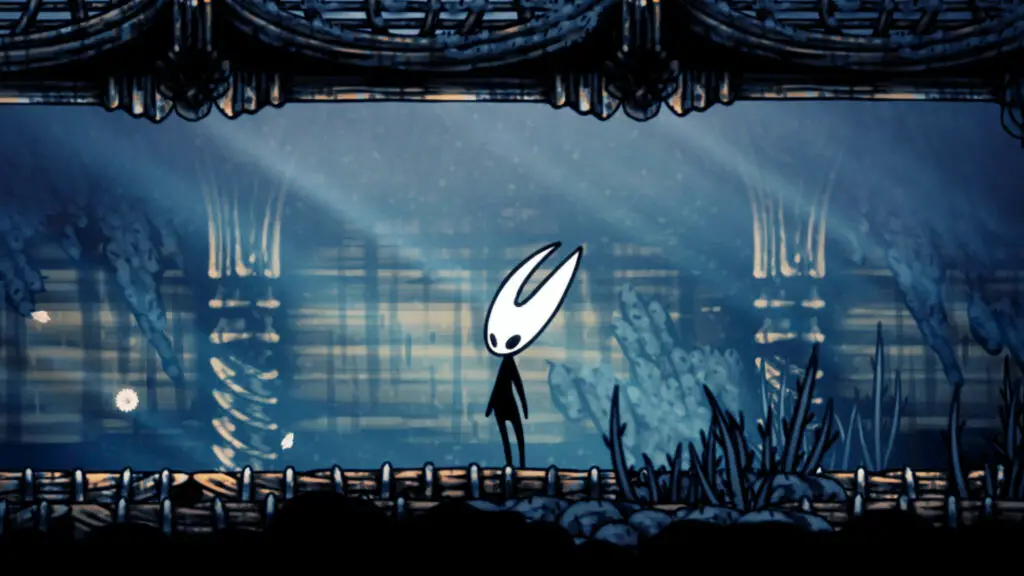 A screenshot of Hollow Knight: Silksong. A close-up shot of main character Hornet with light streaming down on her white head and black body.
