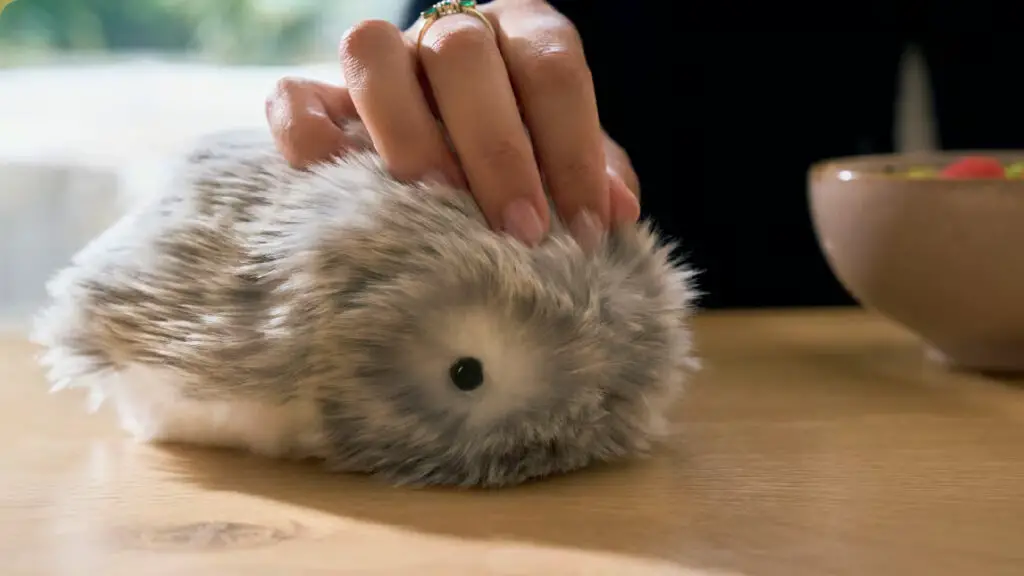 A Casio Moflin, being stroked on a table