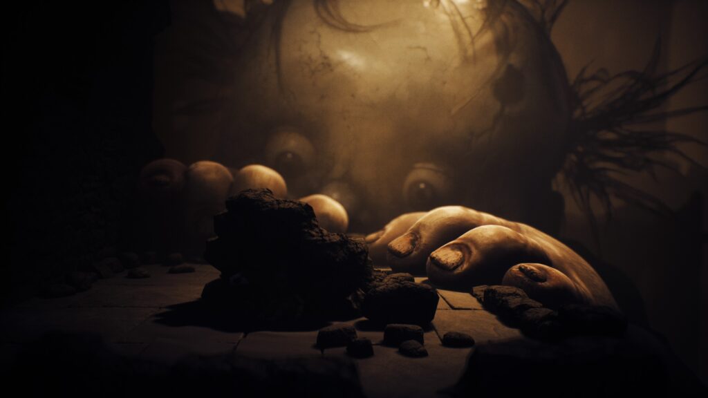 Giant baby monster peering over a rocky ledge in Little Nightmares 3