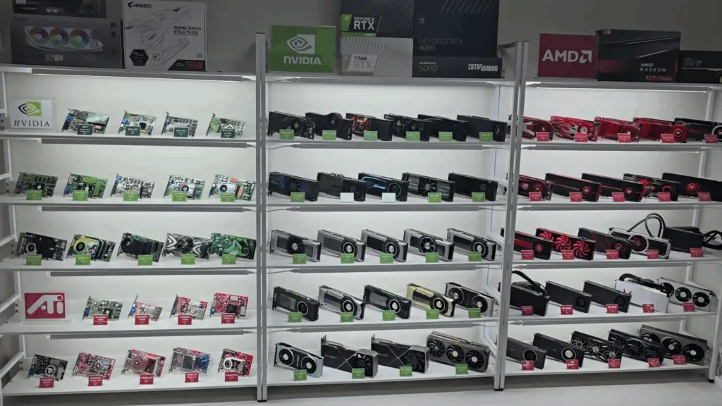 A collection of GPUs, well-lit and carefully lined up along multiple shelving units.