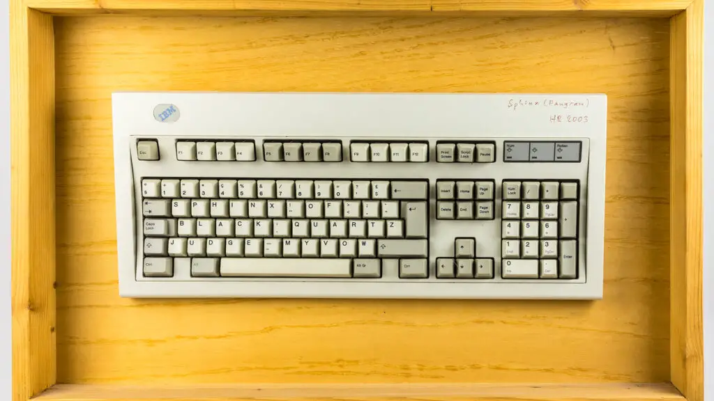 Cropped to 16:9: an IBM Model M keyboard on a wooden background.