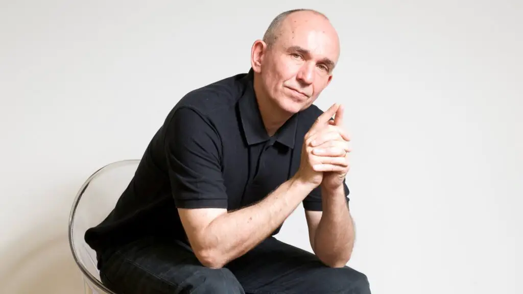 Peter Molyneux in a chair, contemplating.