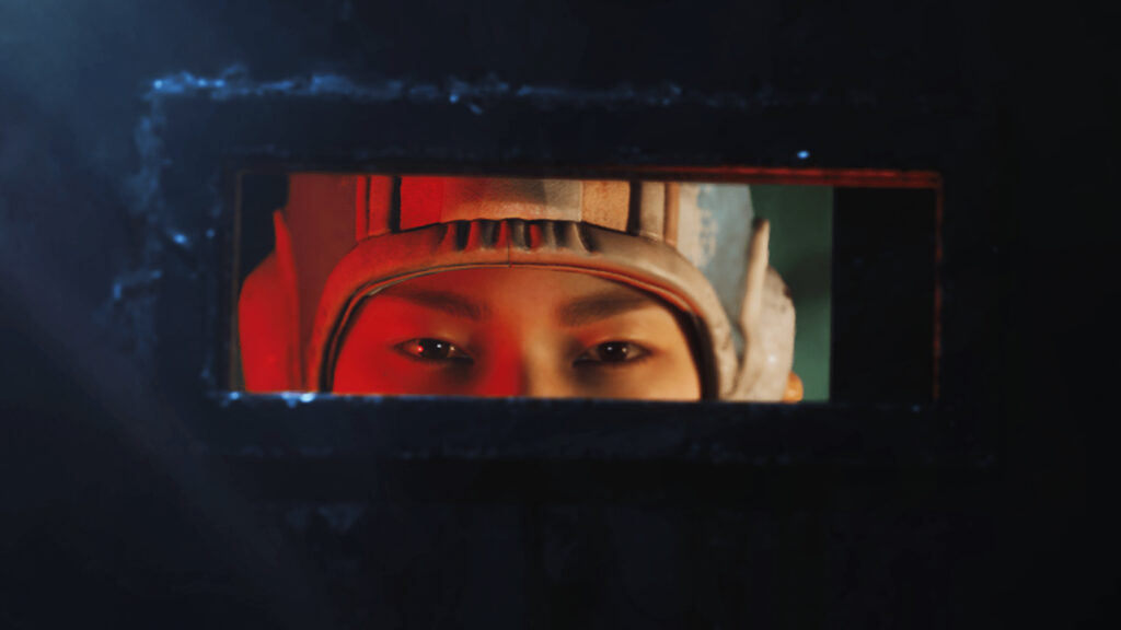 Arc Raiders Market Correction: A close-up of Tian Wen as she peeks through the small, horizontal window of her metal door.