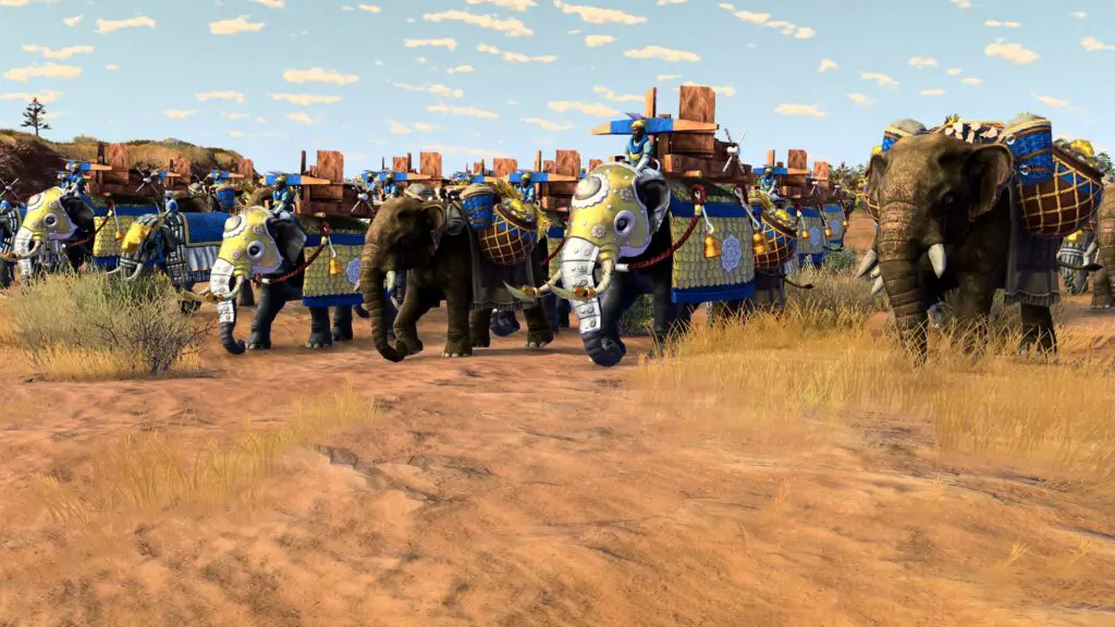 A line of armoured elephants marches across a desert.