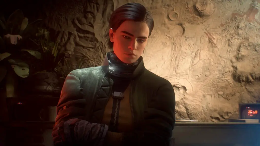 Arc Raiders: An upper-body shot of Celeste standing next to a sandstone wall, looking downwards as if deep in thought.