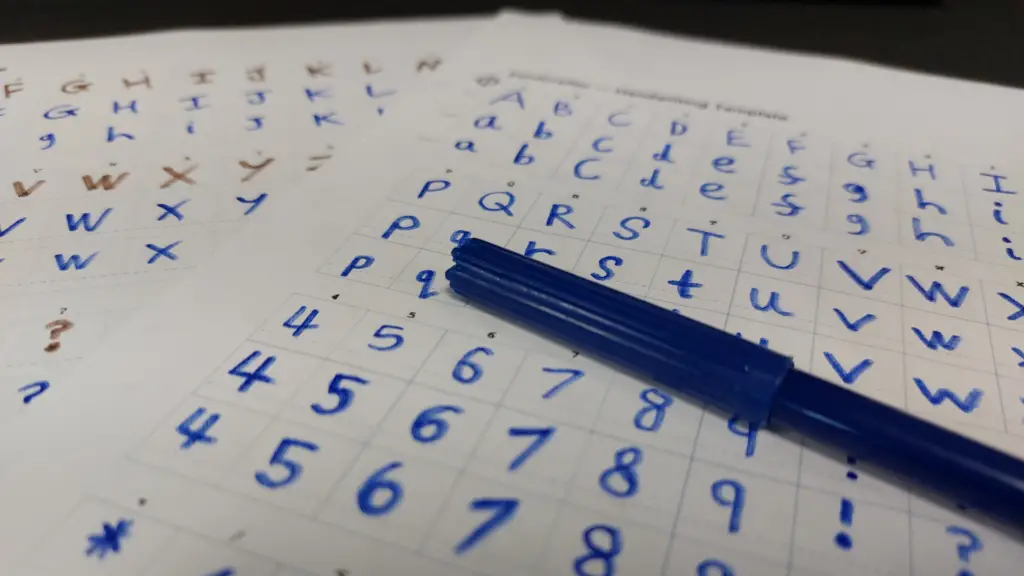 Two sheets of hand written sample characters intended for font creation. A capped, blue felt-tip rests across one of the sheets of paper.