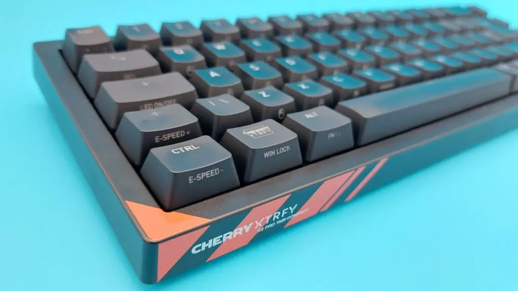 The Cherry K5 Pro TMR Compact seen from an angle on a blue background.