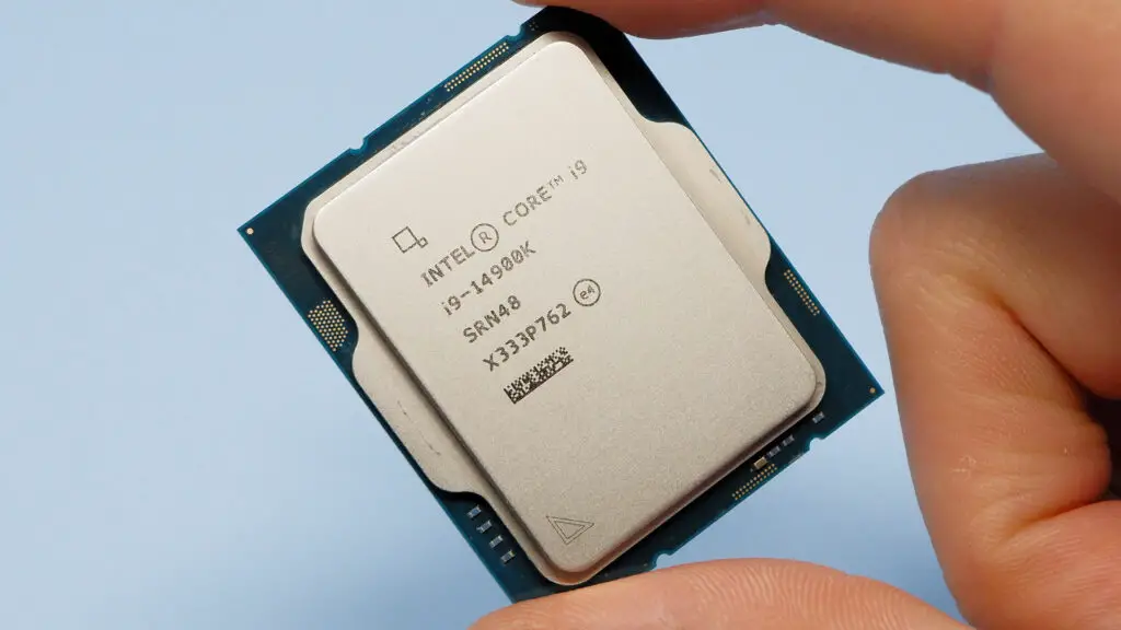 An Intel Core i9 14900K CPU held by a person