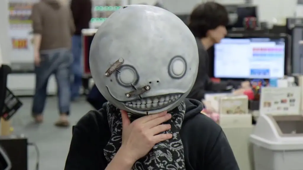 Visionary creator Yoko Taro wearing the iconic Emil mask from the Nier series