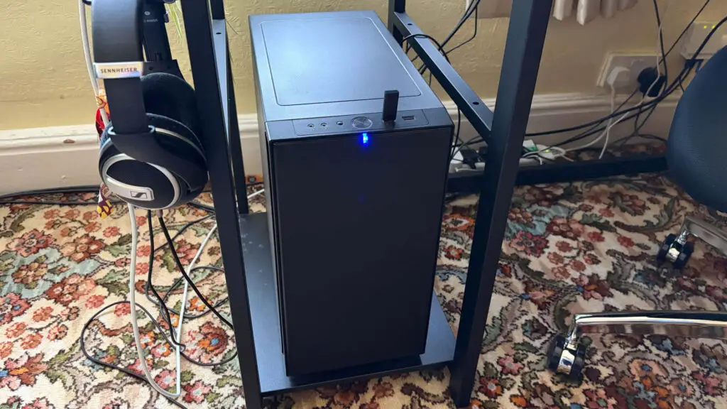 A PC placed on a dedicated low shelf of a desk