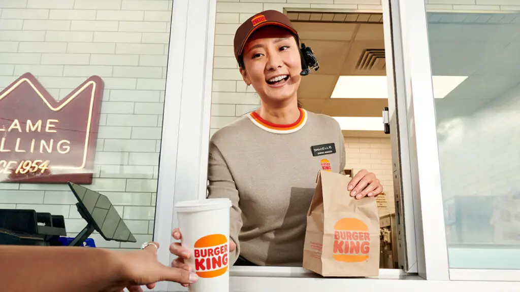 A Burger King employee at the drive-thru window