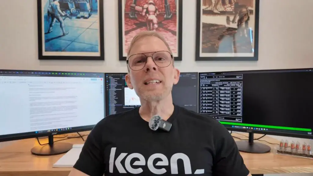 John Carmack at his workstation with Ode to id posters