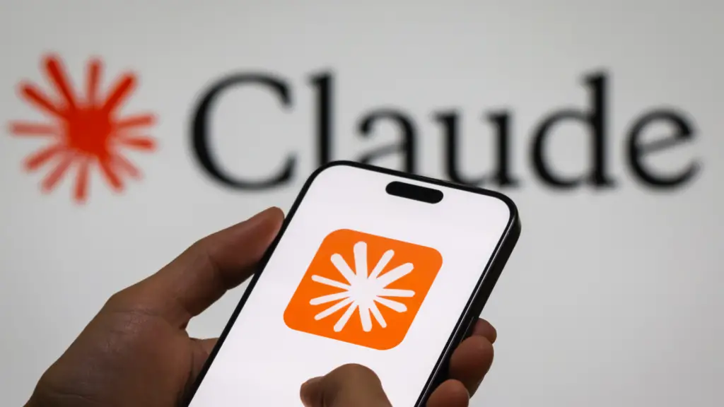 A person holds a smartphone displaying the logo of Claude, an AI language model by Anthropic.
