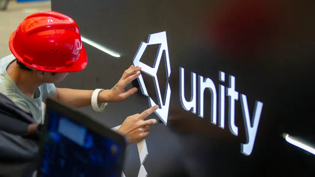 A worker installs Unity logo at Unity Technologies booth