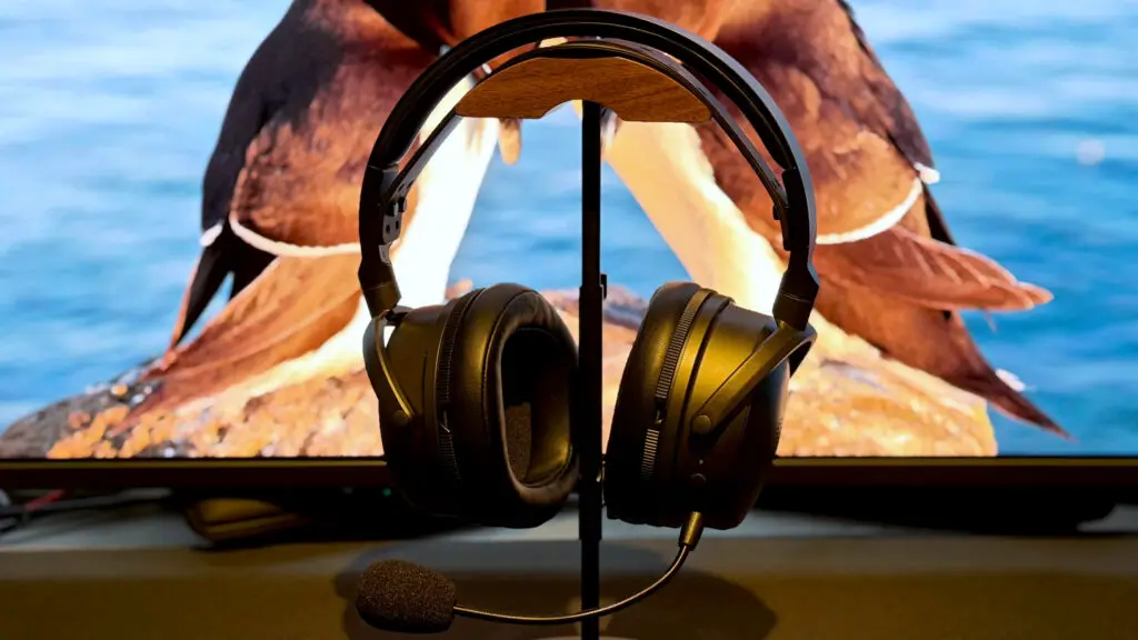 Audeze Maxwell 2 wireless gaming headset on a desk with a gaming monitor
