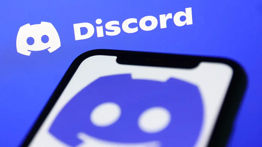 Discord logo displayed on a phone screen illustrating the revised age verification strategy.