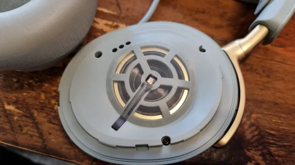 An exposed carbon fiber and brass driver within the SteelSeries Arctis Nova Elite gaming headset