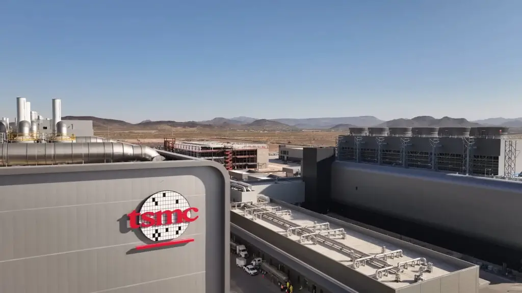 The outside of TSMC Arizona, showing the desert and the mountains in the distance next to the TSMC logo