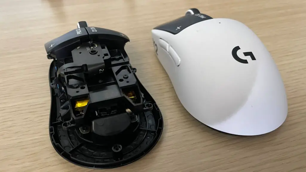 A Logitech G Pro X2 Superstrike gaming mouse next to a version of it with its shell off, showing its internals.
