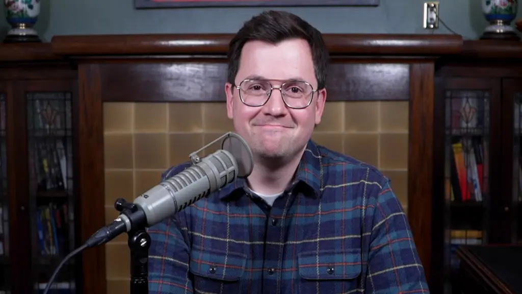 Norman Caruso, the Gaming Historian, smiles at the camera with a microphone in front of him.