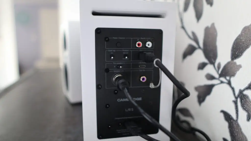 Cambridge Audio's L/R S speakers on a desk. The speakers are white with black tweeters.