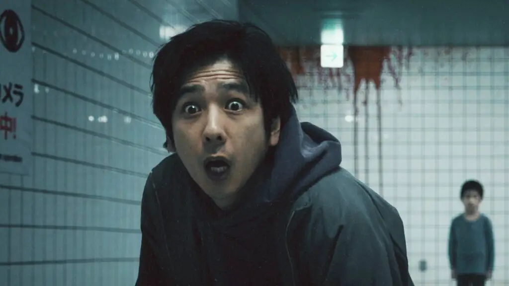 A cinematic shot of a man witnessing a blood-stained wall in the subway.