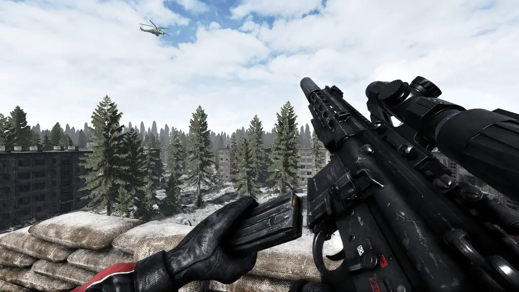 The player loads a magazine into a rifle while overlooking a snowy region in Road to Vostok.