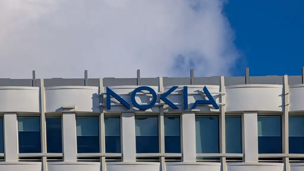 A large blue Nokia logo is mounted on the white facade of the Nokia corporate office building in Munich, Bavaria, Germany.